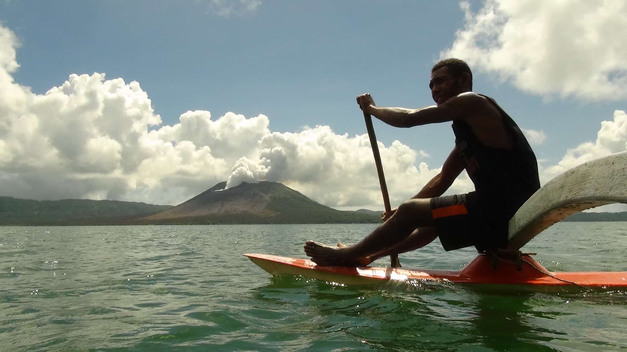 man canoeing on a volcanic lake